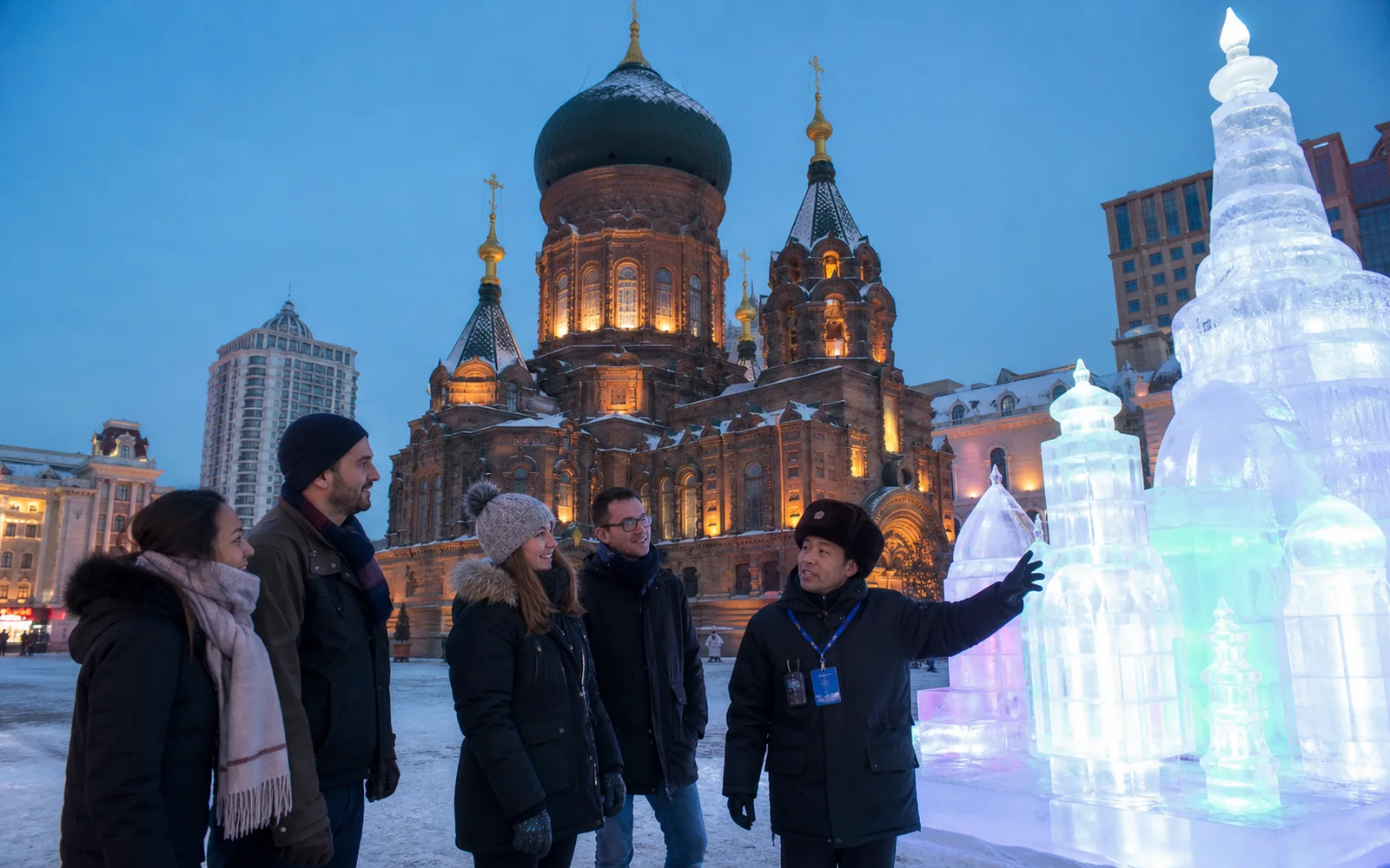 International travelers with a Harbin guide near Saint Sophia Cathedral and illuminated ice sculptures