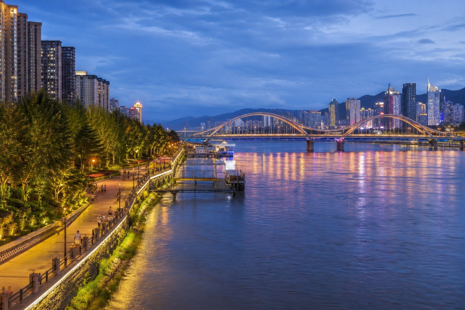Lanzhou city lights reflected across the Yellow River at blue hour