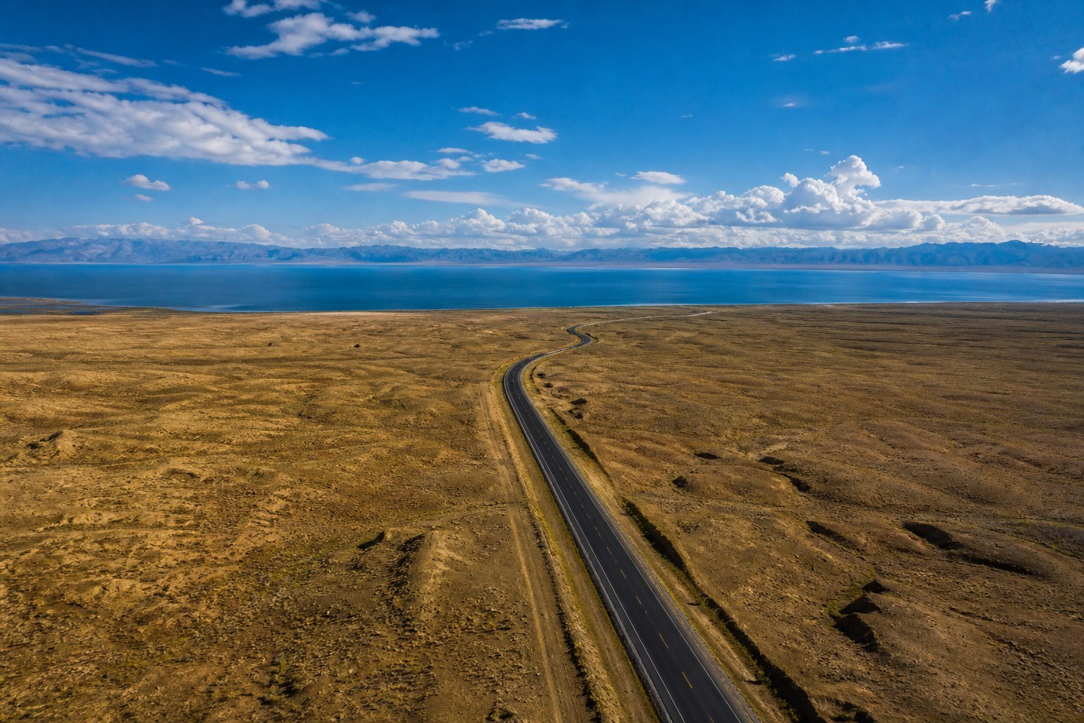 S21 highway crossing the desert toward blue Ulungu Lake in northern Xinjiang