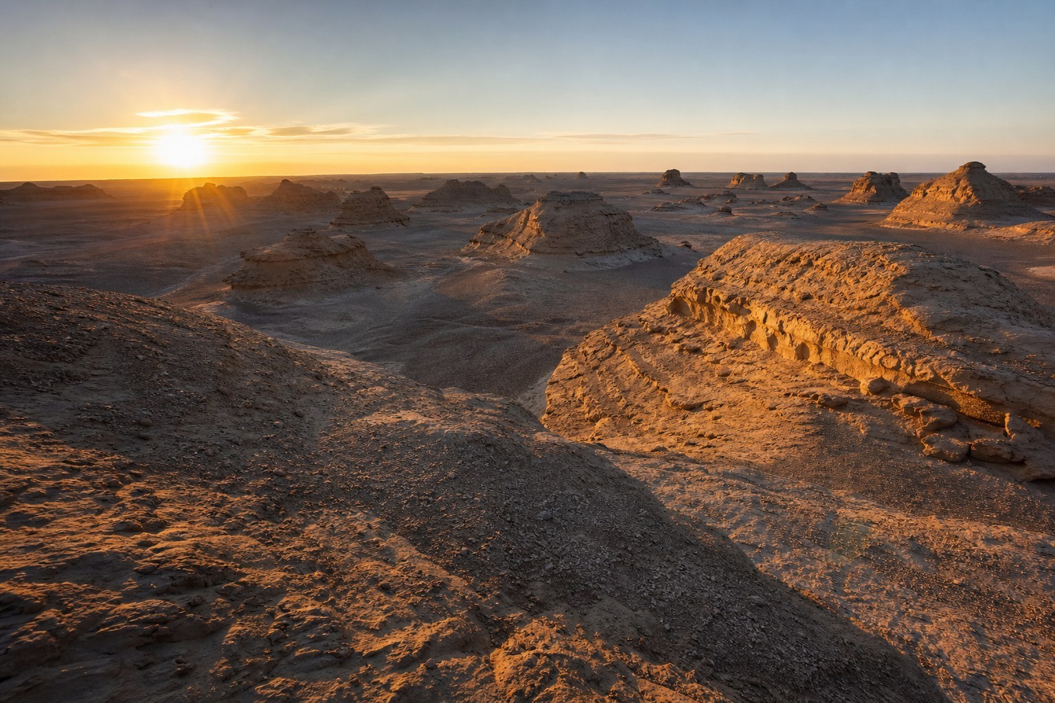 Wind-eroded yardang landforms at Urho Ghost City during golden hour