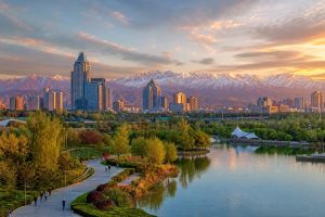 Urumqi city park, landscaped lake and skyline beneath the Tianshan Mountains