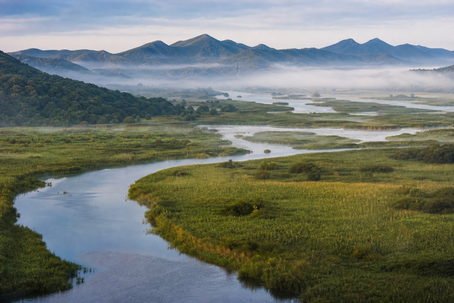 Fangchuan wetland, winding waterways and forested hills near Hunchun