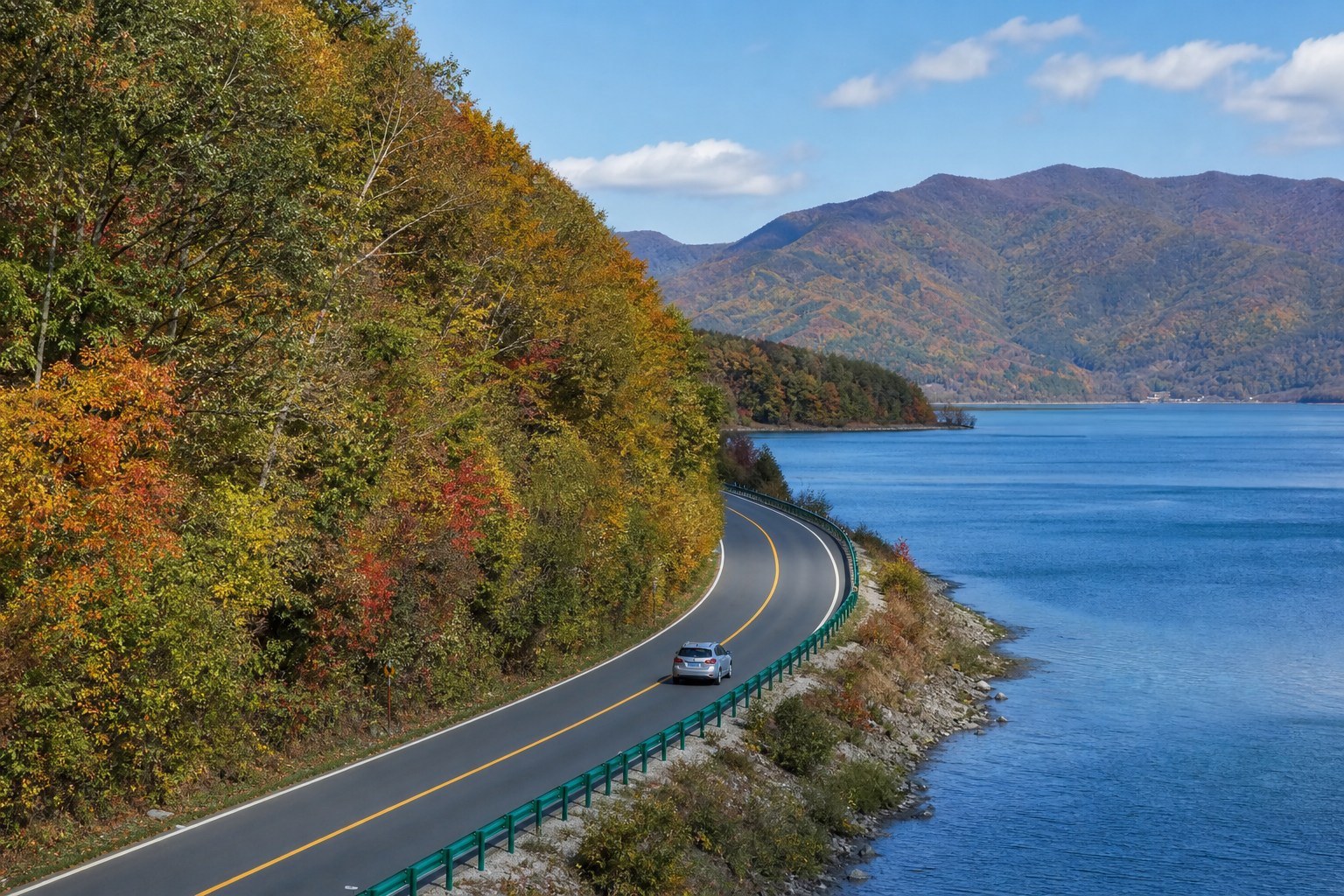 Highway 331 winding beside a river and forested mountains near Kuandian