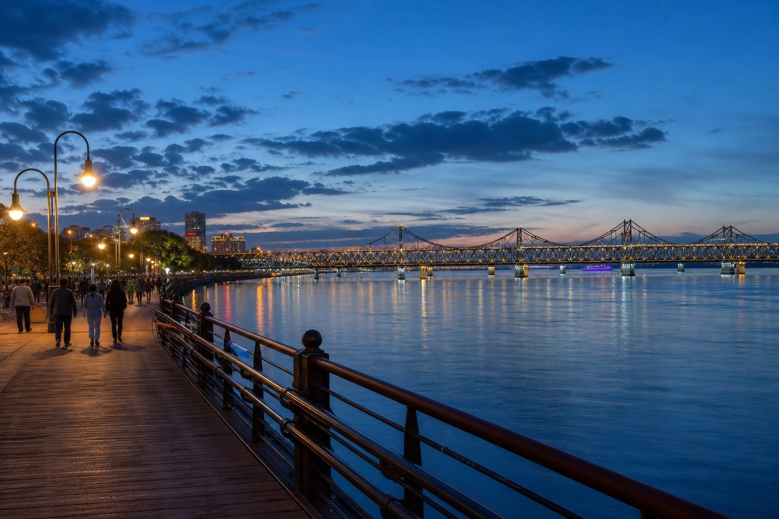 Dandong promenade overlooking the Yalu River and historic bridge at blue hour