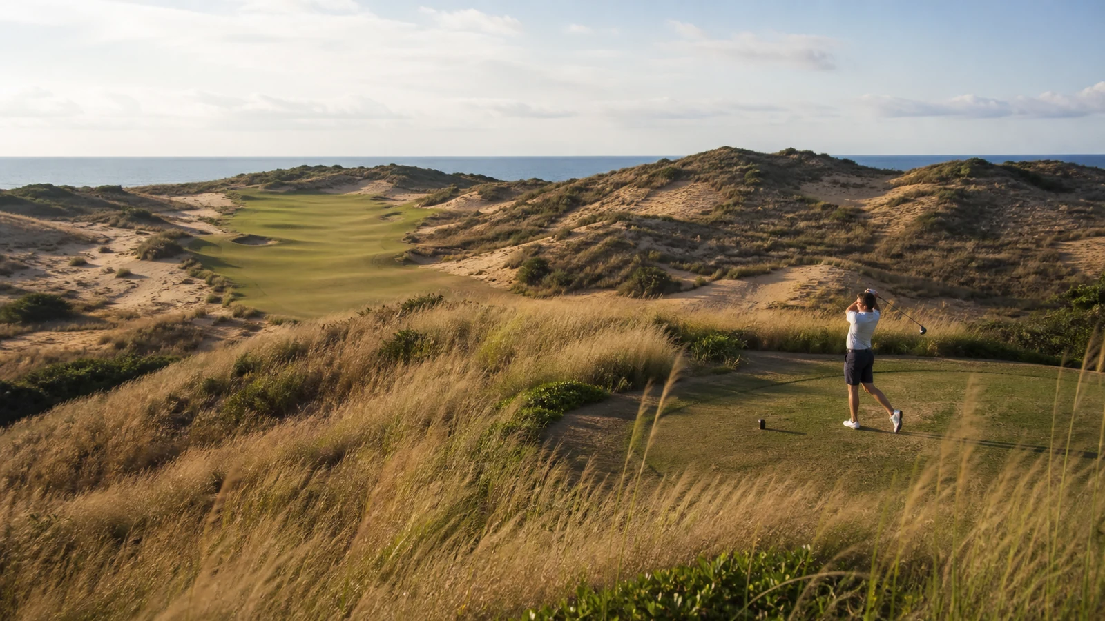 Golfer playing across coastal dune terrain in Wanning, Hainan