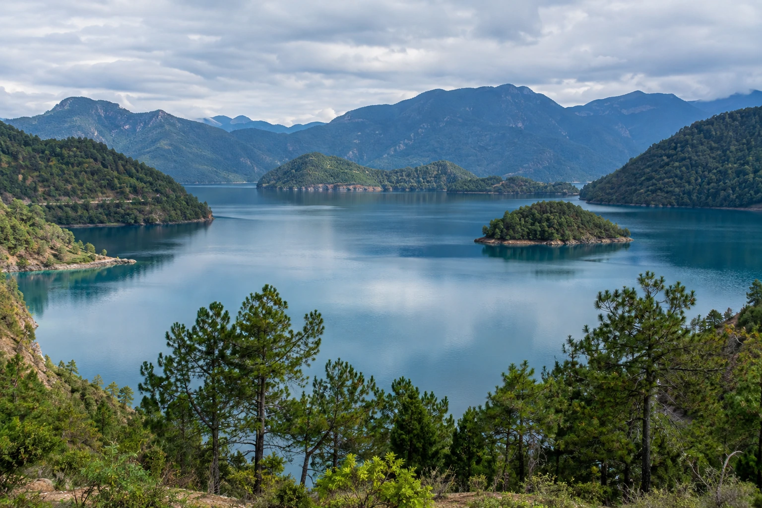 Blue water and wooded shores at Lugu Lake