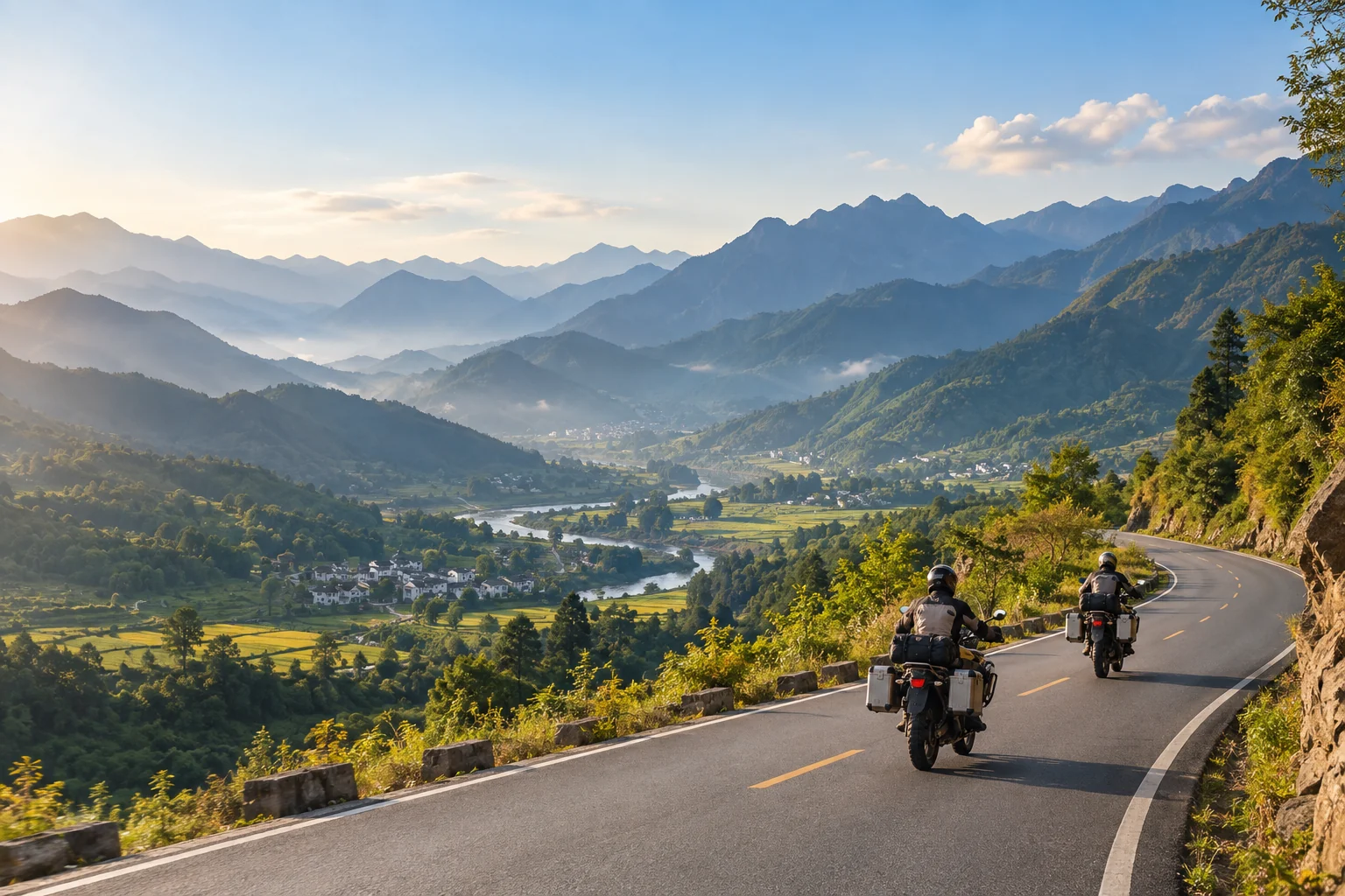 Two motorcycle riders following a winding road through a green mountain valley