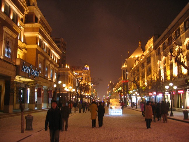 Illuminated historic shopfronts along a Harbin pedestrian street at night