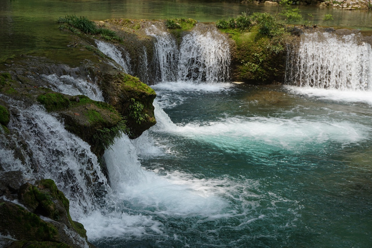 Waterfalls among trees and mossy rocks at Xiaoqikong in Libo