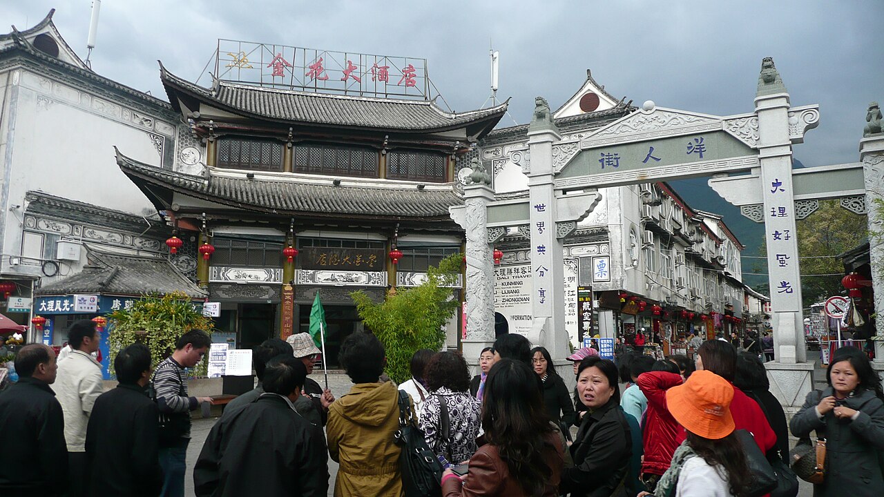 Visitors at a stone gateway and traditional buildings in Dali Old Town