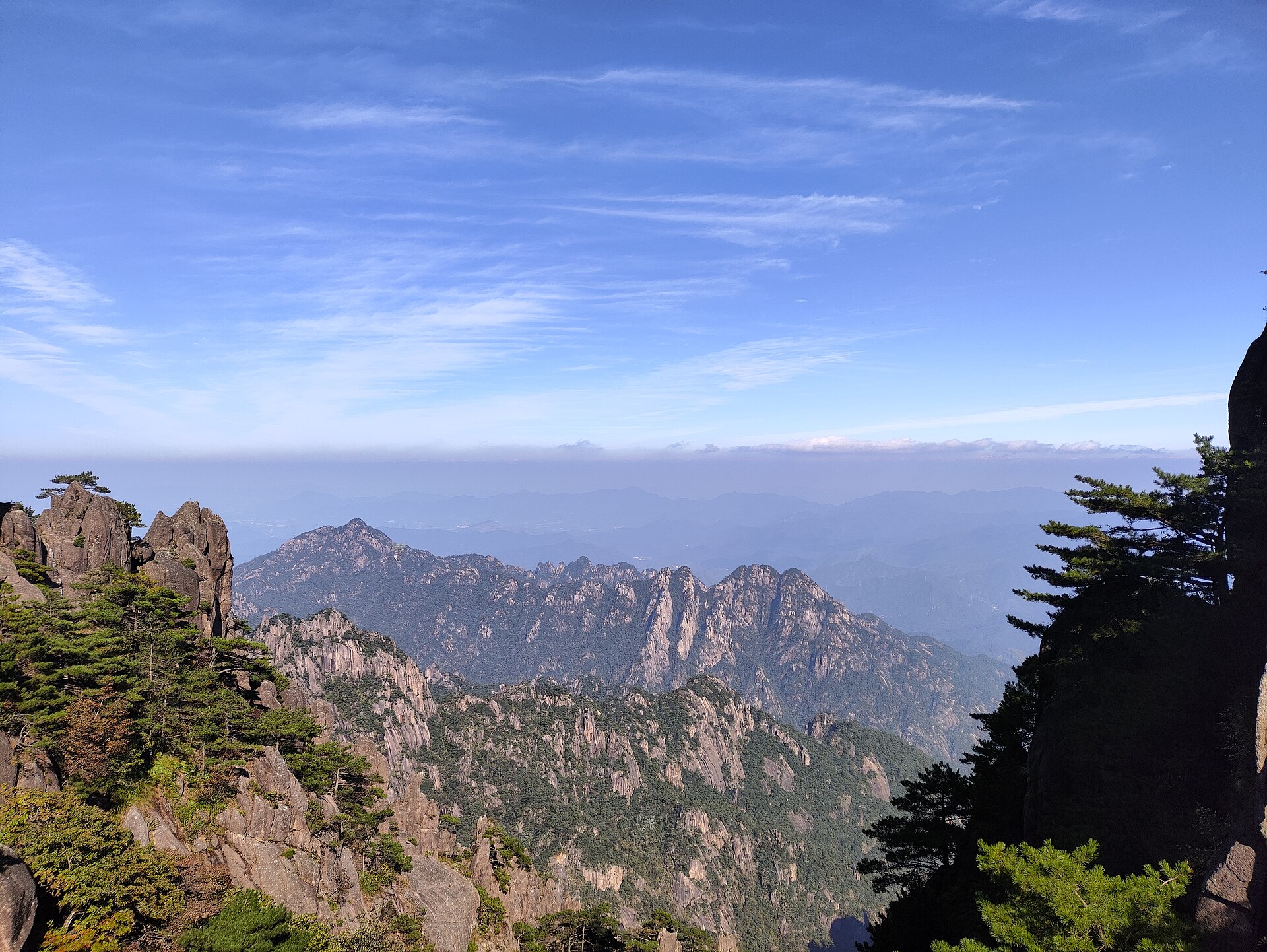 Granite ridges and pine trees beneath a blue sky at Huangshan