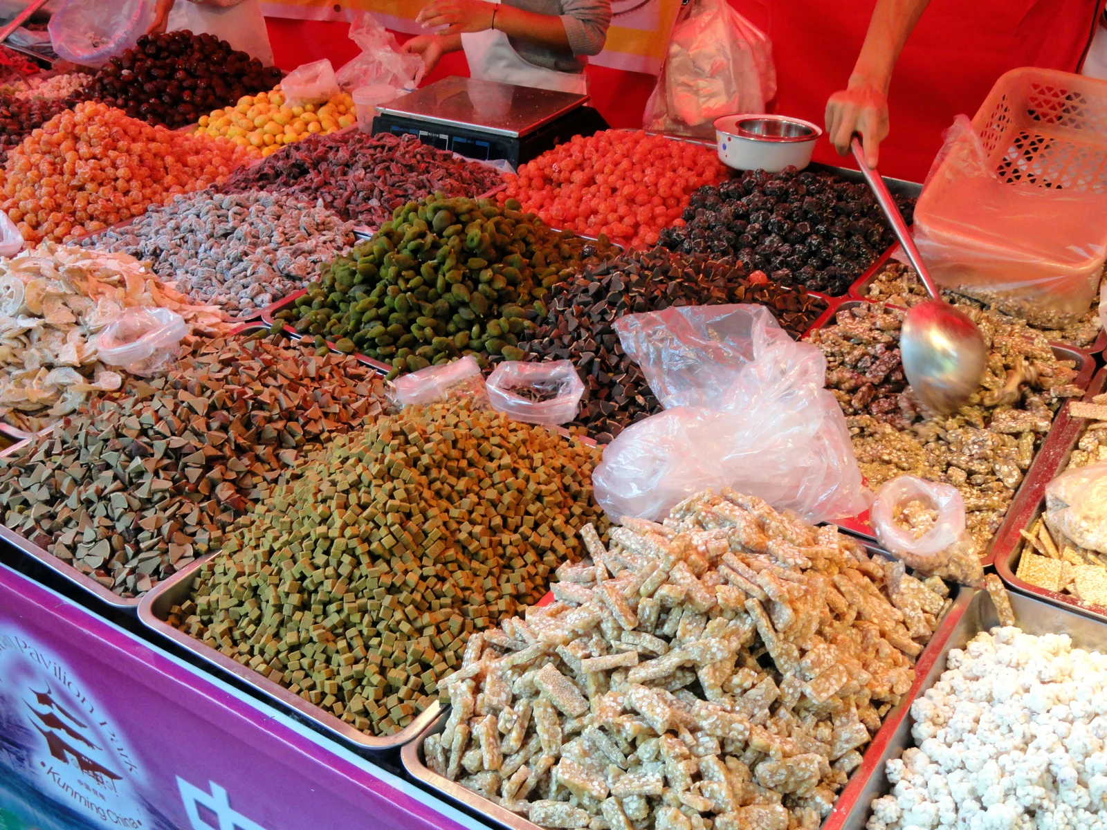 Trays of colourful sweets and preserved snacks at a Kunming stall