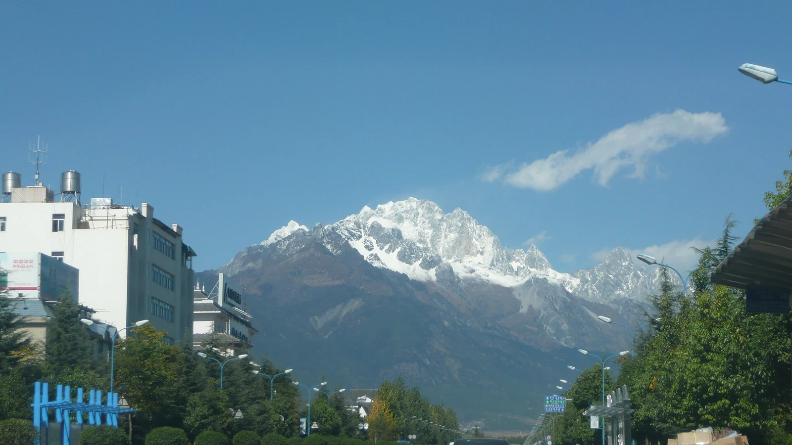 Street in Lijiang with snow-covered mountains in the distance