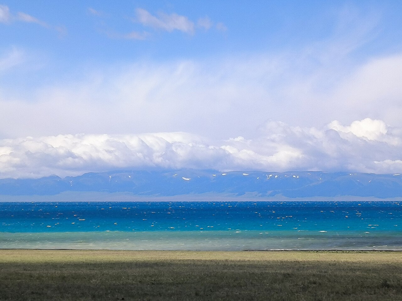 Open water and mountain scenery at Sayram Lake in Xinjiang
