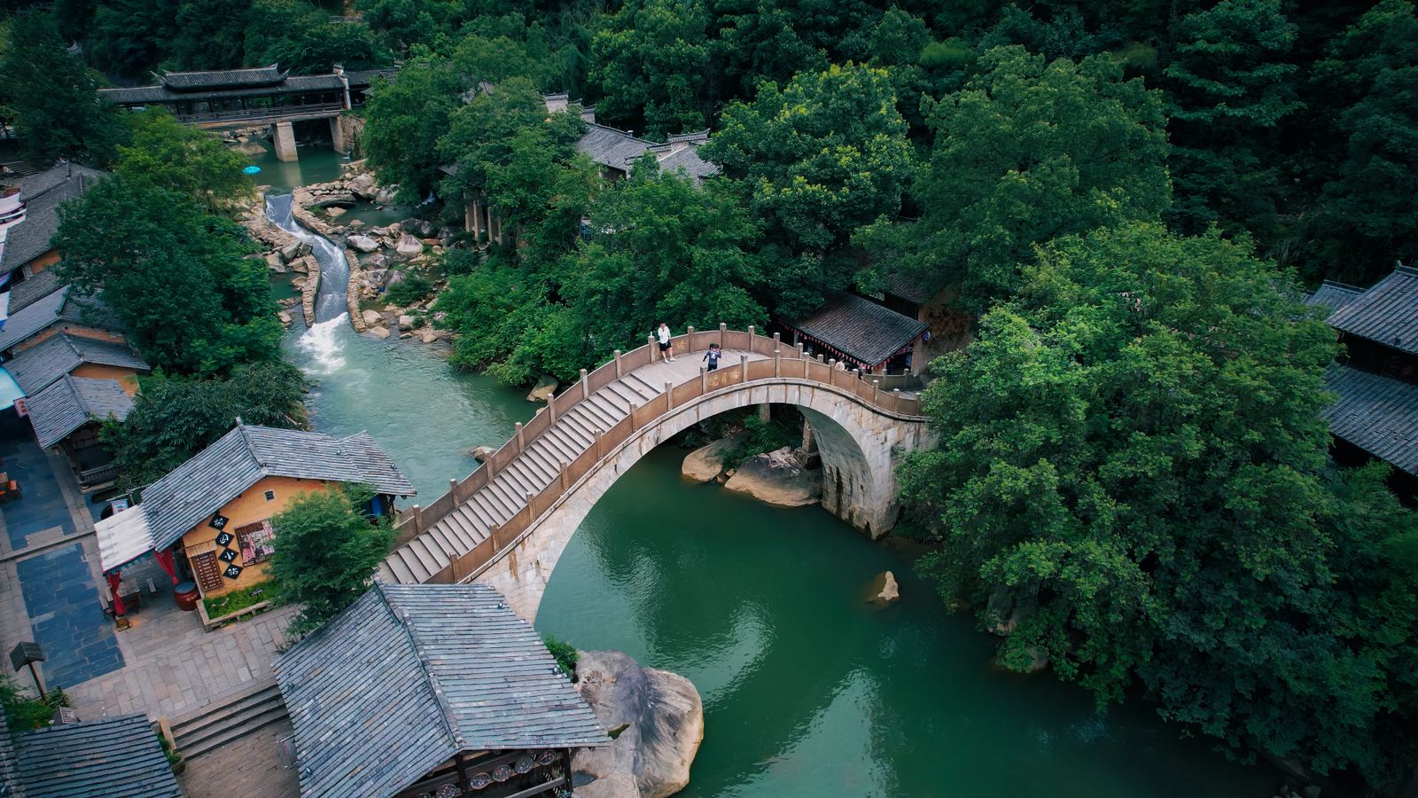 An arched stone bridge with steps over the stream at Wangxian Valley