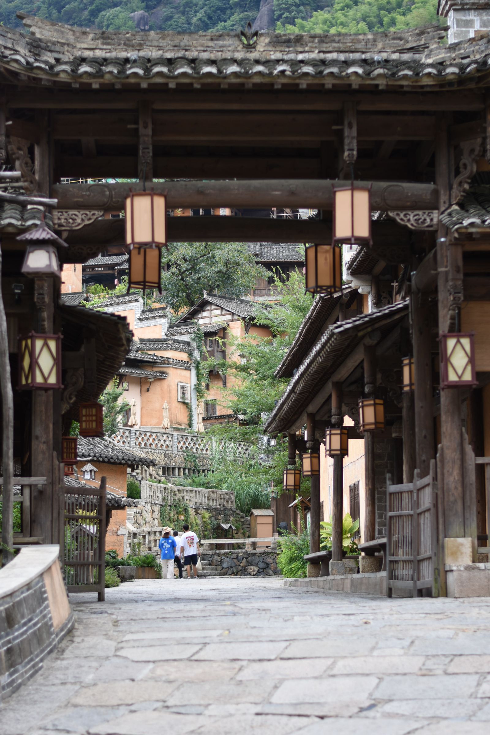 Lanterns, tiled roofs and stone steps along a street at Wangxian Valley