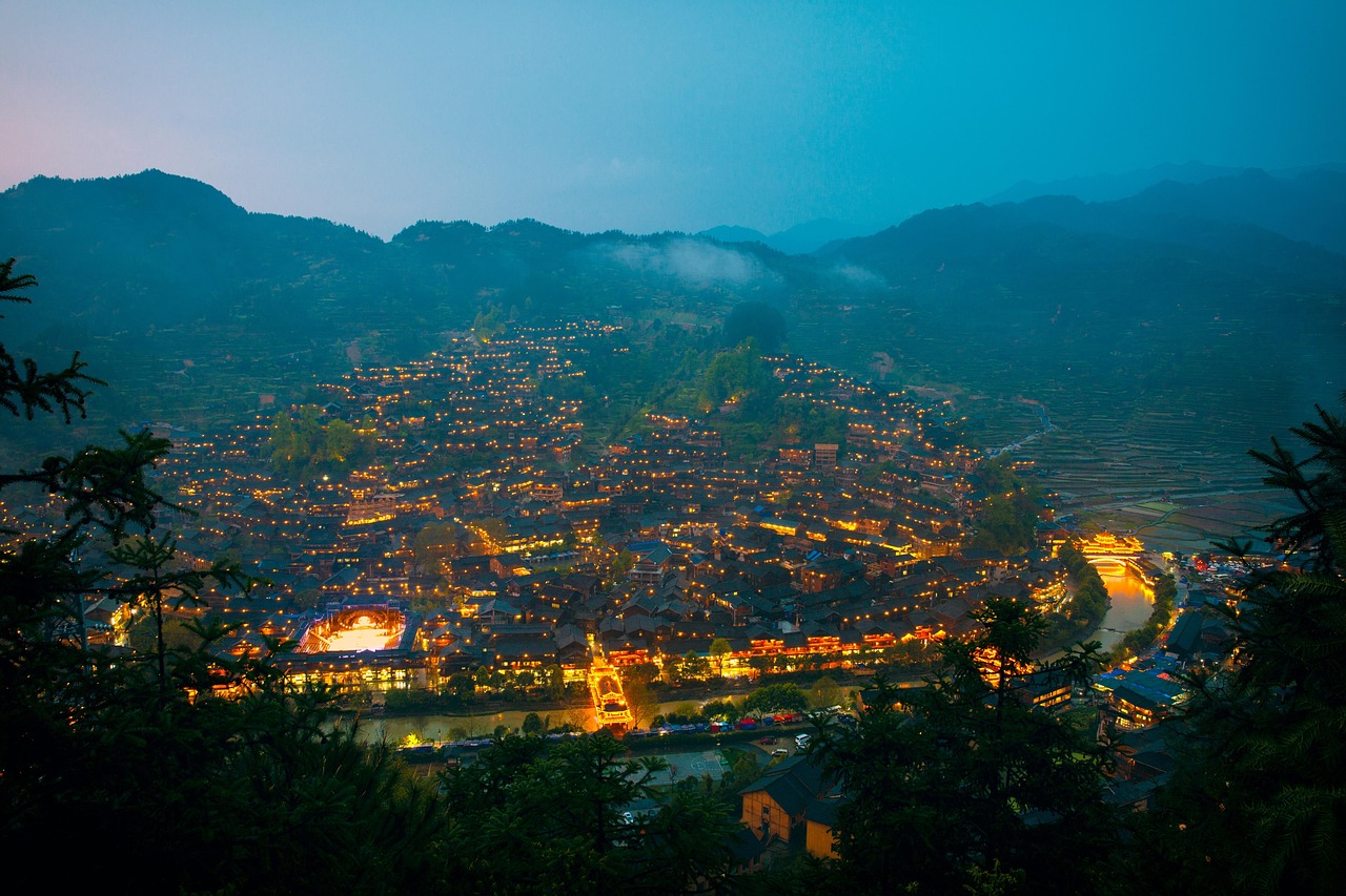Hillside houses illuminated at night in Xijiang Miao Village