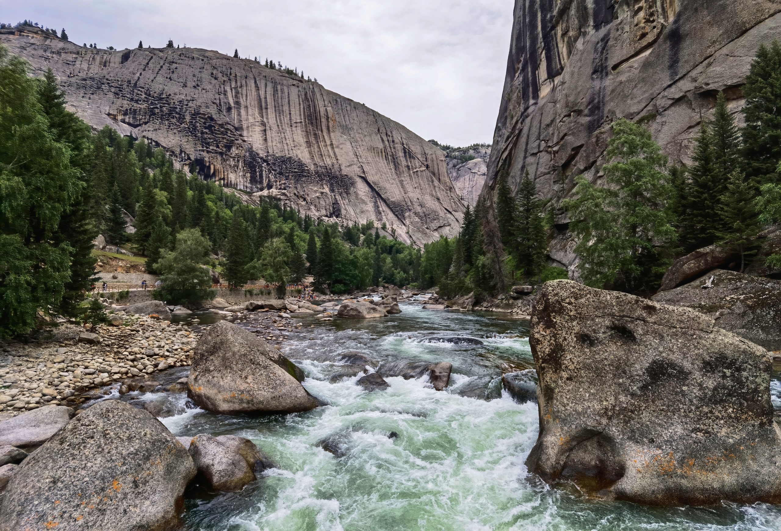 Irtysh River flowing between granite cliffs and forest in Koktokay, Fuyun, Xinjiang